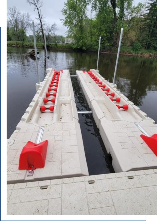 A dock with two red floats on the water.