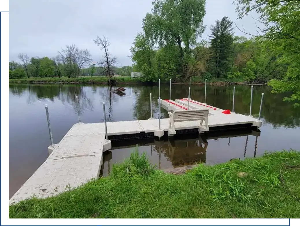 A dock with a bench on it next to a body of water.