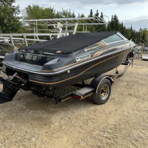 A 1993 Celebrity 180 Boat is parked on a trailer in a dirt lot.