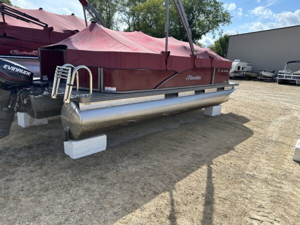 A 2020 Manitou 20' Pontoon boat parked in a parking lot.