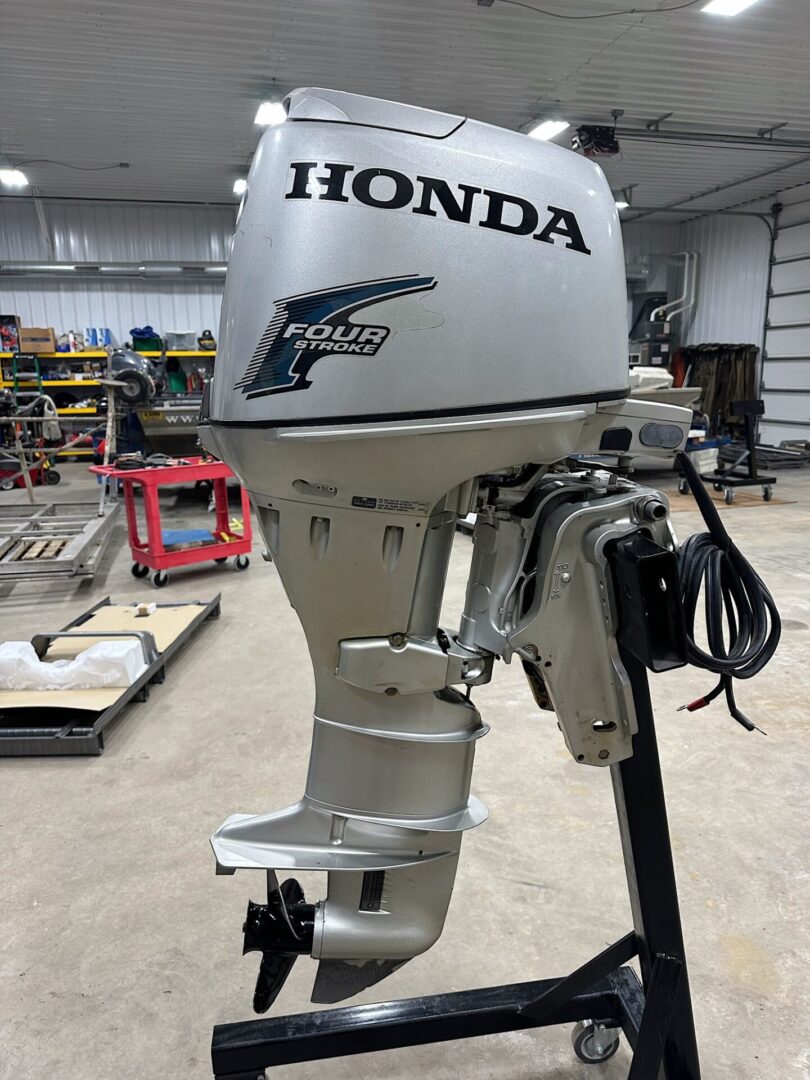 Silver Honda four-stroke outboard motor on stand