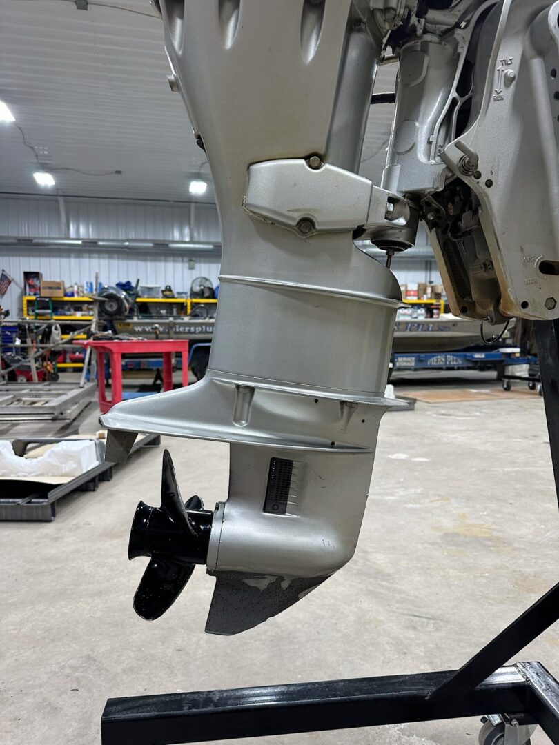 Silver outboard motor lower unit with propeller