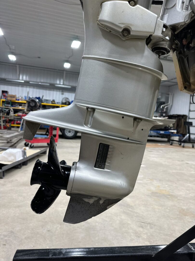 Silver outboard motor lower unit with propeller