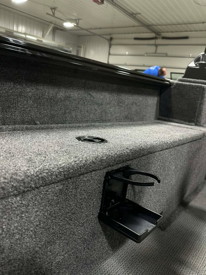 Carpeted boat interior with fold-out cup holder