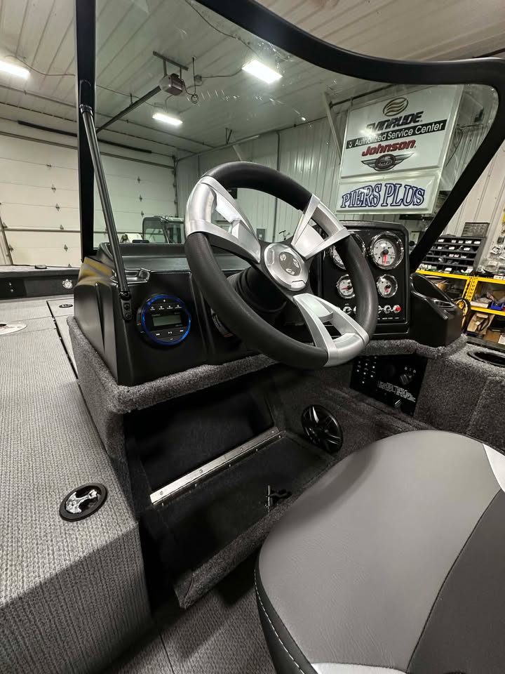 Carpeted bass boat helm with steering wheel