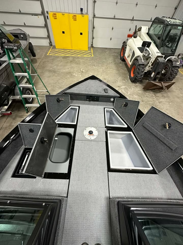 Carpeted fishing boat bow with open compartments