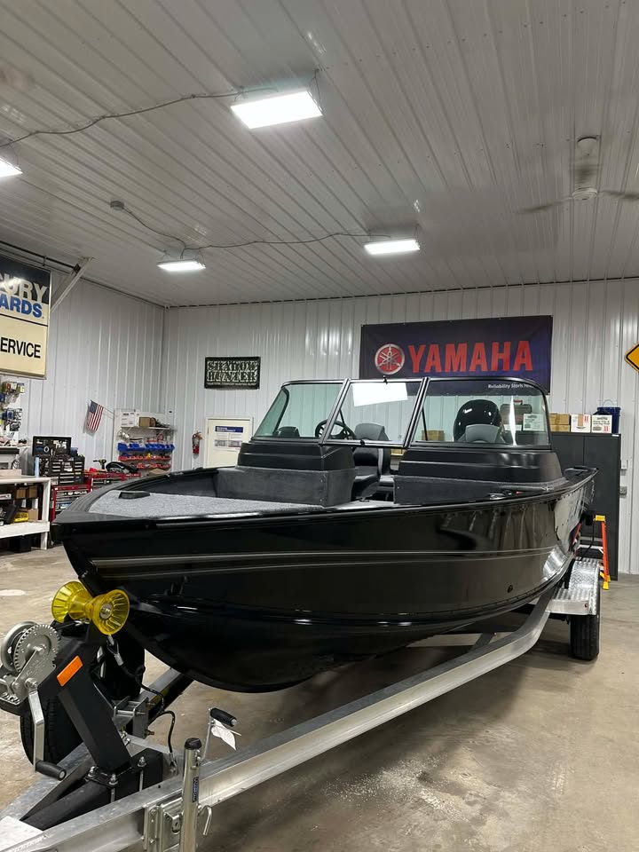 Sleek black motorboat on trailer in showroom