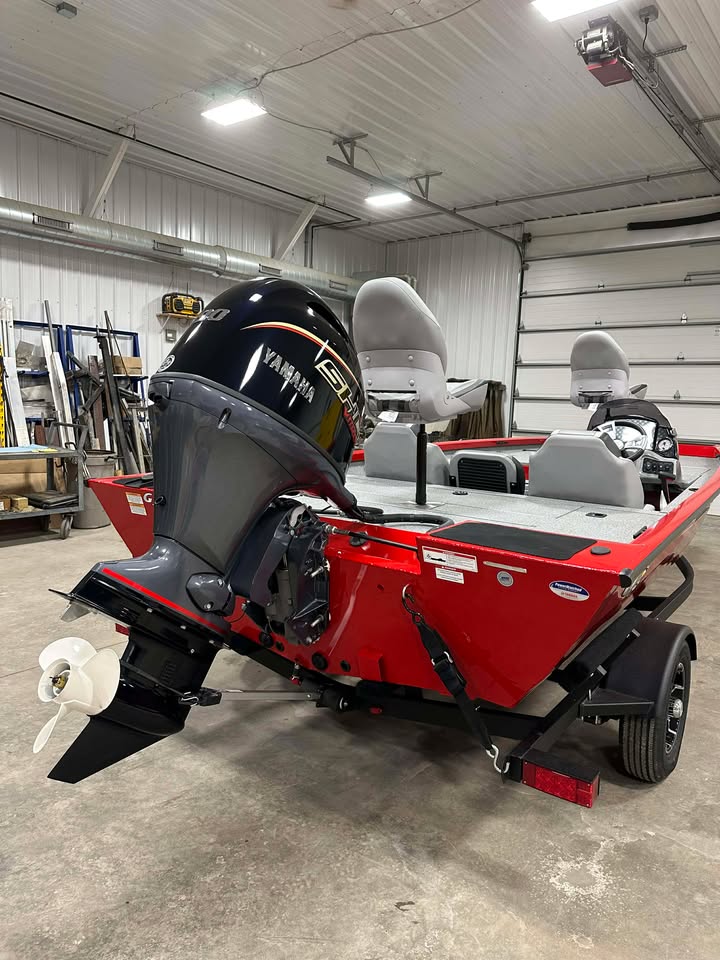 Red bass boat on trailer with Yamaha outboard