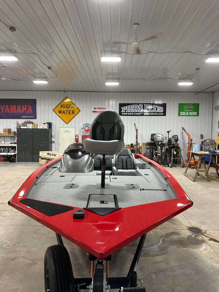 Red bass fishing boat on trailer in workshop
