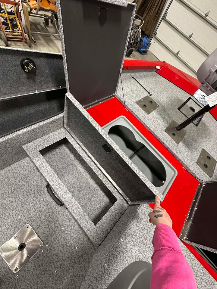 Open fishing boat hatch revealing storage compartment