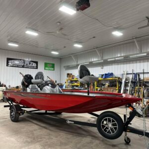 Red bass boat on trailer inside workshop