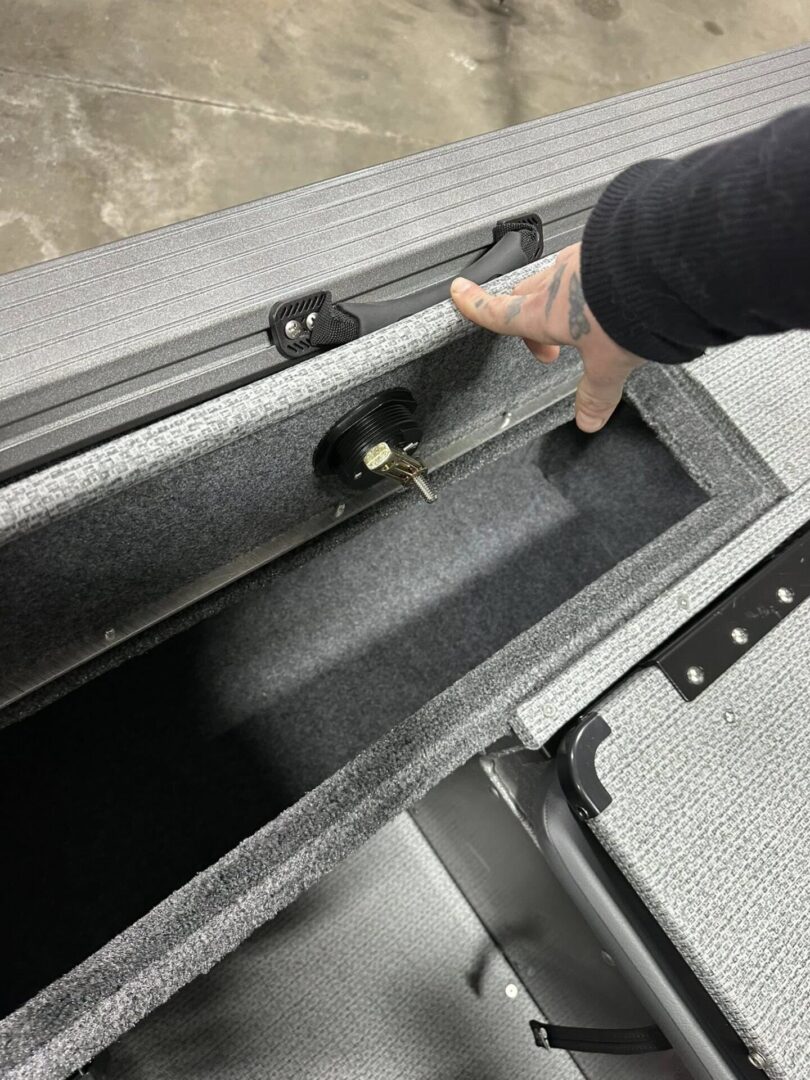 Hand opening carpeted storage compartment