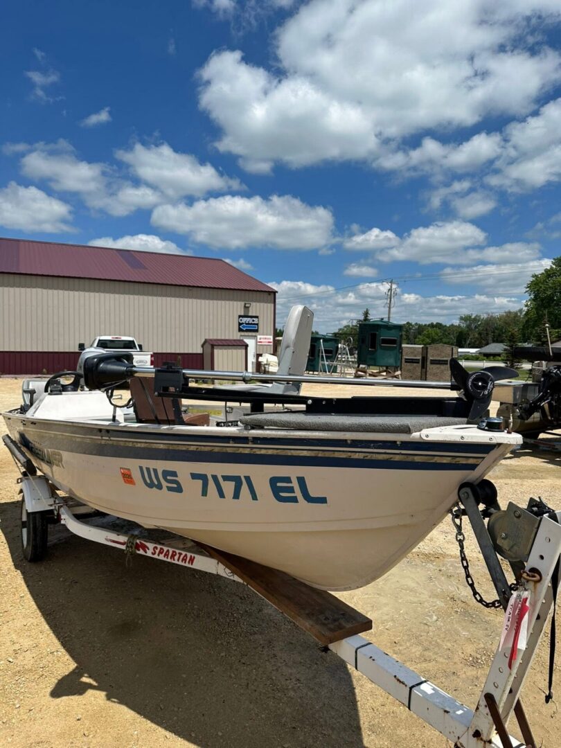 Boat on Spartan trailer parked outside workshop
